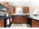 Functional kitchen area with dark cabinetry, tile flooring, black appliances, and ample counter space at 18163 W Addie Ln, Surprise, AZ 85374
