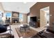 Spacious living room featuring a fireplace, neutral tile flooring, and comfortable leather furniture at 18163 W Addie Ln, Surprise, AZ 85374