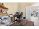 Home office with desk, chair, shelves, and view to outside porch at 18163 W Addie Ln, Surprise, AZ 85374