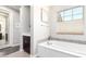 Bright bathroom showcasing a soaking tub with a window, complemented by dark wood cabinets and neutral walls at 1930 W Yellowstone Way, Chandler, AZ 85248