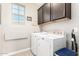 Laundry room featuring a washer, dryer, dark wood cabinets, and tiled floor at 1930 W Yellowstone Way, Chandler, AZ 85248