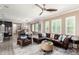 Bright living room featuring a leather sofa, ceiling fan, and an open floor plan to the dining area at 1930 W Yellowstone Way, Chandler, AZ 85248