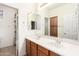 Bathroom featuring a double sink vanity with wood cabinets, large mirror, and adjacent room at 2146 S Drexel --, Mesa, AZ 85209