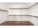 Spacious walk-in closet with wood floor, multiple shelves, and hanging rods for optimal organization at 2146 S Drexel --, Mesa, AZ 85209
