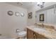 Charming bathroom featuring a vanity with granite countertop, framed mirror, and updated fixtures at 2315 E Cholla St, Phoenix, AZ 85028