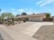Charming home featuring a well-maintained front yard and long driveway leading to a two-car garage at 2315 E Cholla St, Phoenix, AZ 85028