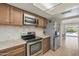 Well-lit kitchen boasting modern stainless steel appliances, granite countertops, and ample cabinet space at 2315 E Cholla St, Phoenix, AZ 85028