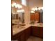 Bathroom features double sinks, light countertop and wood cabinetry with large mirrors at 2401 E Rio Salado Pkwy # 1225, Tempe, AZ 85288