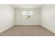 A carpeted bedroom with a bright window offers comfortable living space at 24356 W La Salle St, Buckeye, AZ 85326