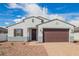 Inviting single-story home with a neat front yard featuring low-maintenance landscaping and a paver driveway at 24356 W La Salle St, Buckeye, AZ 85326