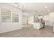 Open living space with a kitchen featuring white cabinets, an island, and stainless steel appliances at 24356 W La Salle St, Buckeye, AZ 85326