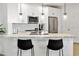 Well-lit kitchen offers stainless steel appliances, white cabinetry, and a sleek breakfast bar with black stools at 2511 W Queen Creek Rd # 165, Chandler, AZ 85248