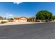 Charming single-story home featuring a three car garage, desert landscaping, and mature shade tree at 2528 N Ashbrook Cir, Mesa, AZ 85213
