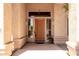 Covered front entrance featuring a solid wood door with sidelights and accent plants at 2528 N Ashbrook Cir, Mesa, AZ 85213