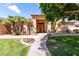Front entrance with a walkway, meticulous landscaping, and mature palm trees at 2528 N Ashbrook Cir, Mesa, AZ 85213