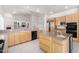 Spacious kitchen with light wood cabinets, granite countertops, and center island, open to living room at 2528 N Ashbrook Cir, Mesa, AZ 85213