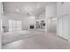 Bright living room featuring neutral paint, carpet, fireplace, and white plantation shutters on sliding doors at 2528 N Ashbrook Cir, Mesa, AZ 85213