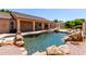 Backyard pool with rock waterfall and a covered patio; great for entertaining at 2528 N Ashbrook Cir, Mesa, AZ 85213