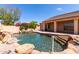 Backyard pool with waterfall and rock features, blending nature with relaxation at 2528 N Ashbrook Cir, Mesa, AZ 85213