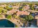 Picturesque aerial view highlighting the home, mature trees, nearby lake, and mountain views at 3750 E Sawtooth Dr, Chandler, AZ 85249