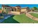 Landscaped front yard with green grass, stone accents, desert plants, and a pathway leading to the house at 3750 E Sawtooth Dr, Chandler, AZ 85249