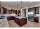 Spacious kitchen features granite counters, stainless steel appliances, a center island with pendant lights, and dark wood cabinetry at 3750 E Sawtooth Dr, Chandler, AZ 85249