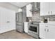 Bright kitchen featuring stainless steel appliances, white cabinets, and tiled backsplash at 3841 E Jasper Dr, Gilbert, AZ 85296