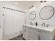 Bathroom featuring a double sink vanity with modern fixtures, round mirrors and recessed lighting at 4128 E Coolbrook Ave, Phoenix, AZ 85032