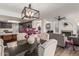 Open concept dining area with modern chandelier, sleek black table, and views to living area with fireplace at 4128 E Coolbrook Ave, Phoenix, AZ 85032