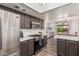 Modern kitchen with stainless steel appliances, gas range, light countertops and an open view to the dining area at 4128 E Coolbrook Ave, Phoenix, AZ 85032
