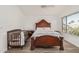 Bright main bedroom featuring a ceiling fan, hardwood floors and a dark wood crib at 4128 E Coolbrook Ave, Phoenix, AZ 85032