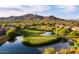 Scenic golf course view showcasing meticulously maintained greens, a pond, and mountain views at 41817 N Bridlewood Way, Phoenix, AZ 85086