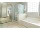 Bright bathroom featuring a separate tub and shower, complemented by neutral tiles and natural light at 4632 S Alamos Way, Gold Canyon, AZ 85118