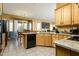 Well-equipped kitchen flows into the dining area, showcasing wood cabinets and black appliances at 4632 S Alamos Way, Gold Canyon, AZ 85118