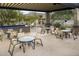 Outdoor patio with tables and seating under a shaded pergola, great for relaxing and entertaining at 4632 S Alamos Way, Gold Canyon, AZ 85118