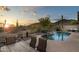 Resort-style backyard features a pool with rock waterfall, desert views and dining area at 4632 S Alamos Way, Gold Canyon, AZ 85118