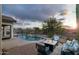 Scenic backyard oasis with a sparkling pool, desert landscaping, lounge seating, and a fire pit at 4632 S Alamos Way, Gold Canyon, AZ 85118