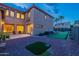 A backyard with a putting green, and patio seating with a two-story home in the background at 4894 E Palm Beach Dr, Chandler, AZ 85249