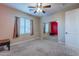 Bedroom featuring a ceiling fan, carpeted floors, large windows, and a mirrored closet at 4894 E Palm Beach Dr, Chandler, AZ 85249
