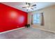 Bright bedroom features a ceiling fan, carpeted floors, large windows and a bright red wall at 4894 E Palm Beach Dr, Chandler, AZ 85249