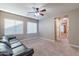 Bedroom featuring a ceiling fan, carpeted floors, and large windows with a leather sofa at 4894 E Palm Beach Dr, Chandler, AZ 85249