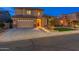 Attractive two-story home with a spacious driveway and illuminated walkway at night at 4894 E Palm Beach Dr, Chandler, AZ 85249