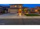 Beautiful two-story home with a welcoming entryway and lush landscaping at night at 4894 E Palm Beach Dr, Chandler, AZ 85249