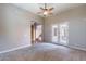 Spacious living area featuring cozy carpet, stylish ceiling fan, and French doors to the outdoor space at 4894 E Palm Beach Dr, Chandler, AZ 85249