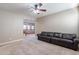 Living room featuring carpeted floors, a ceiling fan, and a comfortable leather sofa at 4894 E Palm Beach Dr, Chandler, AZ 85249