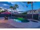 Backyard features pool, tropical landscaping, patio, and inviting ambiance under twilight skies at 4894 E Palm Beach Dr, Chandler, AZ 85249