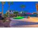 Inviting backyard pool featuring lush landscaping, palm trees, and a tranquil water feature, perfect for relaxation at 4894 E Palm Beach Dr, Chandler, AZ 85249