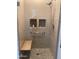 Contemporary shower featuring a glass door, seat, tiled surround, and built-in toiletries shelves at 5350 E Deer Valley Dr # 2435, Phoenix, AZ 85054