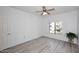 Bright bedroom featuring wood-look floors, ceiling fan and natural light from a window with white shutters at 5350 E Deer Valley Dr # 2435, Phoenix, AZ 85054