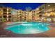 Resort style pool and spa illuminated at night with lounge chairs and umbrellas at 5350 E Deer Valley Dr # 2435, Phoenix, AZ 85054